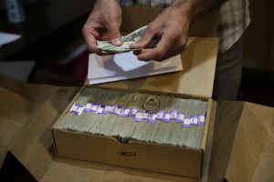 In this June 27, 2017 file photo, the proprietor of a medical marijuana dispensary prepares his monthly tax payment, over $40,000 in cash, at his Los Angeles store. Congress on Wednesday, Feb. 13, 2019, was urged to fully open the doors of the nation's banking system to the legal marijuana industry, a change that supporters say would reduce the risk of crime and resolve a litany of problems for pot companies from paying taxes to getting a loan. (AP Photo/Jae C. Hong, File)