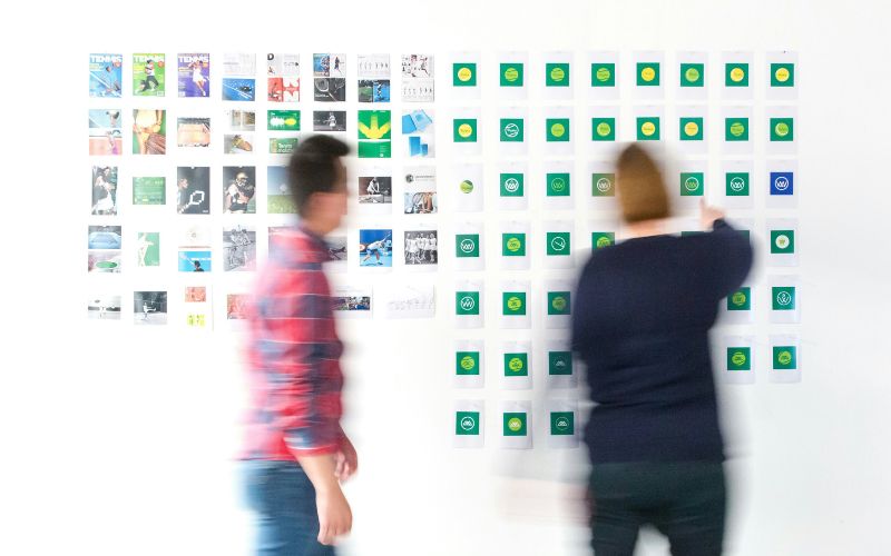 Two brand professionals move about in a blur while planning a campaign