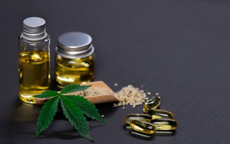 Cannabis flower and various CBD products on a gray background
