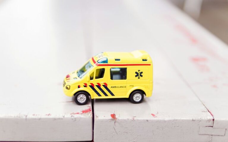 Toy ambulance close up on a wood bench