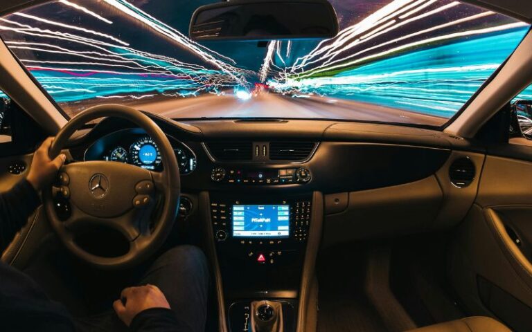 A person behind the wheel as the exterior blurs