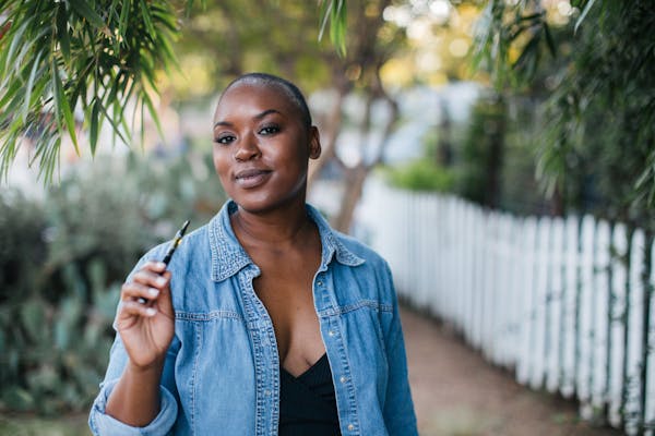 a woman holds a vape device