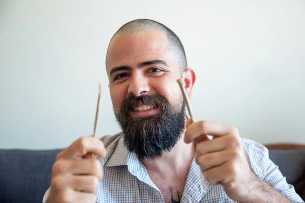 man holds up two pre rolls